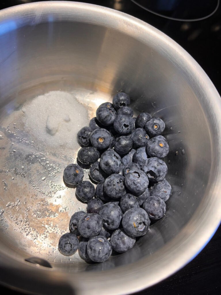 Blueberries and sugar in a pan