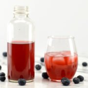 glass and bottle of blueberry kombucha