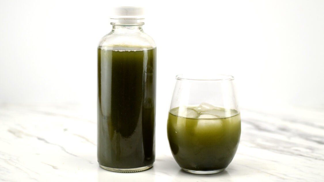 bottle and glass of green kombucha