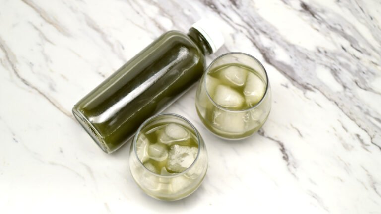 bottle and glasses of green kombucha