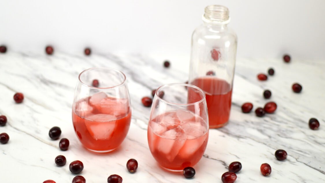 glasses and bottle of cranberry kombucha