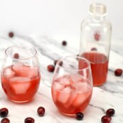 glasses and bottle of cranberry kombucha