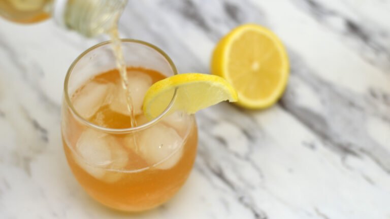 pouring lemon kombucha into glass