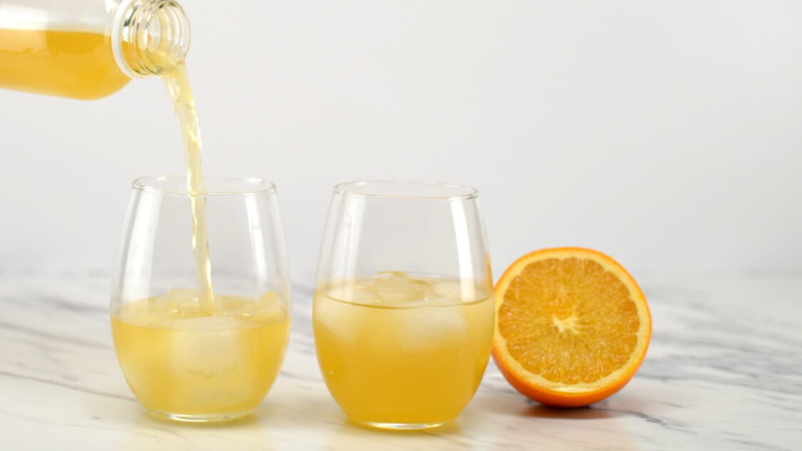 pouring orange kombucha