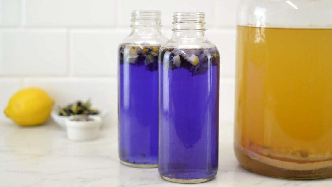 filling bottles butterfly pea lavender lemon kombucha