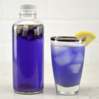 glass and bottle of butterfly pea kombucha